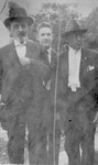 Three Male Individuals Stand Outside by unknown