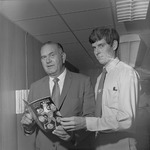 Tom Roberson with Basketball Player holding Media Guide by Opal R. Lovett