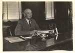 President C.W. Daugette Seated at Desk in Office 1 by unknown