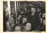 Training School Children Tightly Packed inside Mode of Transportation holding onto Poles by unknown
