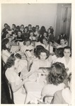 JSTC Female Students at Tables during Meal holding Choir Song Books while Singing by unknown
