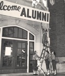 Female Students Hang "Welcome Alumni" Sign Outside Bibb Graves Hall by unknown