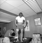 Trainer Mike Jackson Treats Football Player in Training Room 3 by Opal R. Lovett