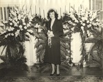 Female Individual Standing in Front of Candelabra and Ferns by unknown