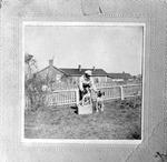 Man and Two Dogs Outside a Home with Fence by unknown