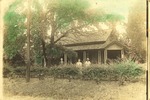 Three Individuals Outside Dwelling, circa early 1900s by unknown