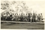 Group of Men and Women Seated on Railing Outdoors, circa 1950s by unknown
