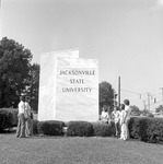 Students Gather Around University Sign by Opal R. Lovett