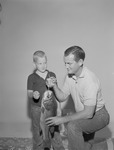 Portrait, Man Kneeling Holding Fish with Boy Standing Beside Him by Opal R. Lovett