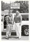 Two Men Beside Automobile Beneath Elrod Motors Sign, circa 1980s by unknown