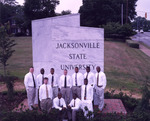 Young men in front of the marble Jacksonville State University sign by unknown