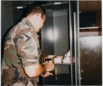 ROTC CDT James Milam Checks Supply Cabinet 2, circa 1985 by unknown