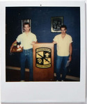 Two Individuals Standing in Rowe Hall Room, circa 1990s by unknown