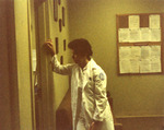 Female Individual Wearing Medical Uniform Standing in Doorway, circa 1980s by unknown