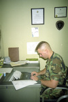 Individual Seated at Office Desk, circa September 1989 by unknown